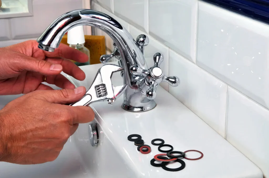 Plumber performing maintenance on a bathroom faucet in North Miami Beach