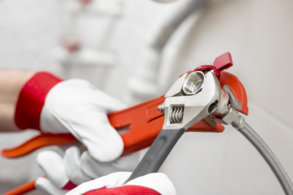 Plumber holding pipe wrenches for an emergency repair in North Miami Beach