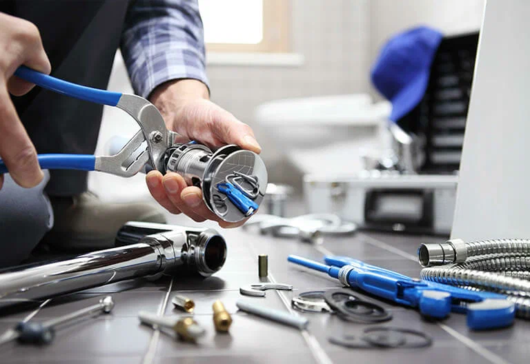 Technician repairing a plumbing fixture with professional tools in North Miami Beach