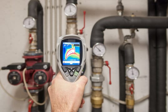 Plumber using a thermal imaging camera to inspect pipes in North Miami Beach