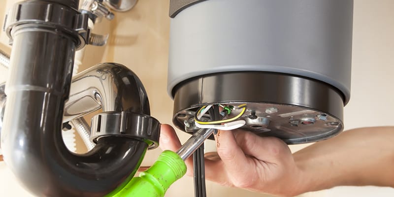 Technician repairing the heating element of a water heater in North Miami Beach
