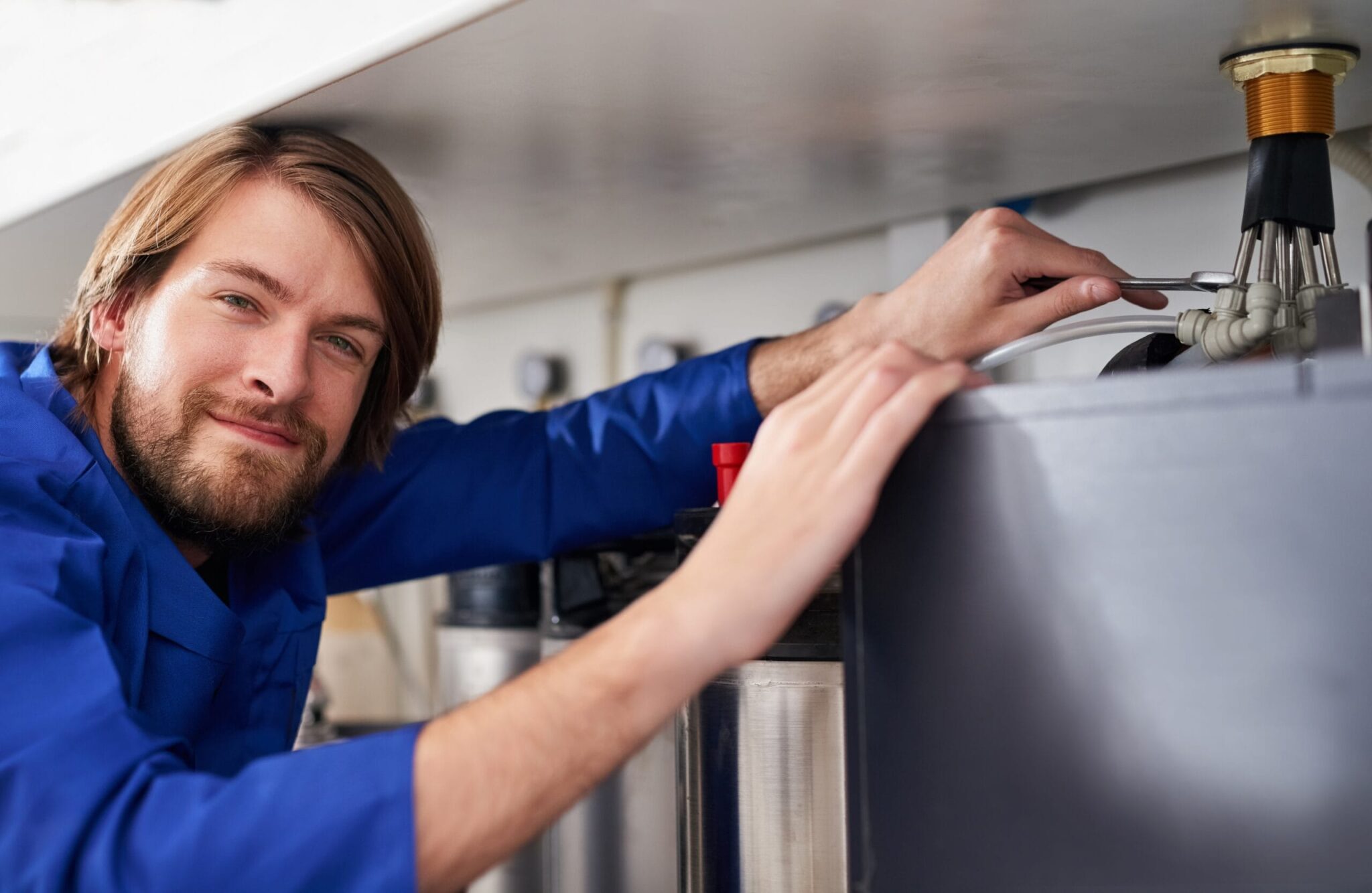 Technician servicing a residential water heater tank in North Miami Beach