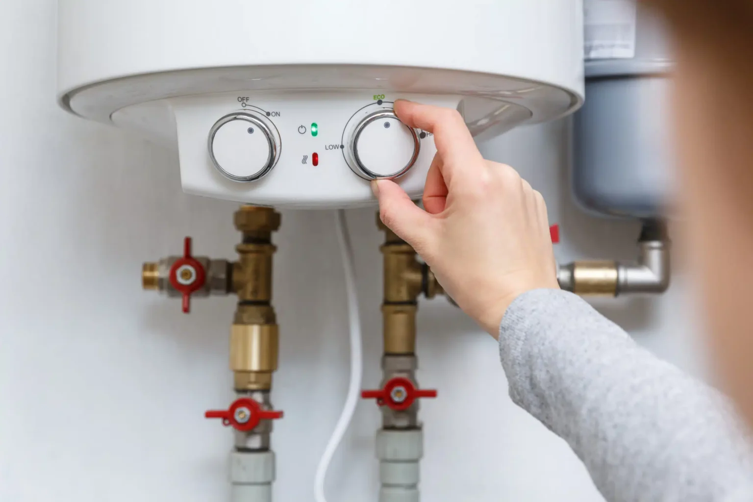 Homeowner adjusting the temperature controls on a water heater in North Miami Beach