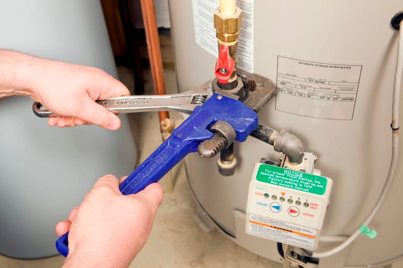Plumber repairing a water heater valve in North Miami Beach